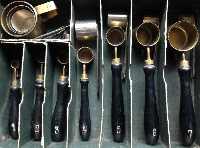 antique boxed set of numbered ebonised handled brass measures plus other measures possibly gun powder tools